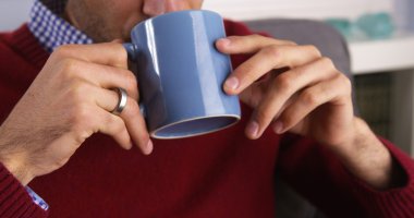 Closeup on a Hispanic man drinking his morning coffee clipart