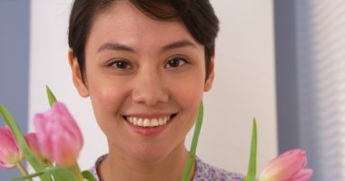 Lale ile gülümseyen çekici Çinli kadın