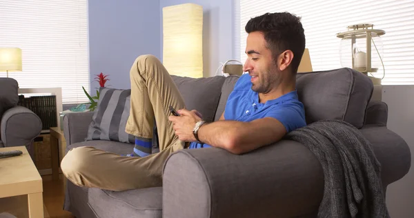 Hombre usando teléfono inteligente en el sofá — Foto de Stock