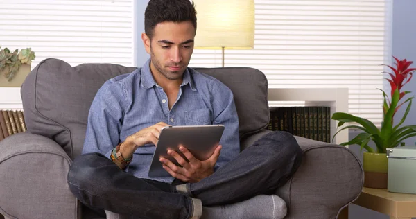 Mexican guy reading on his tablet — Stock Photo, Image