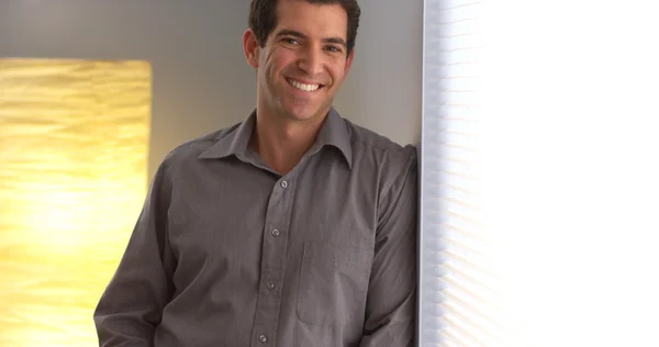 Alkalmi üzletember, mosolyogva, és bámulja az ablakon — Stock Fotó