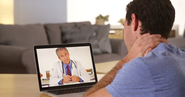 Człowiek za pomocą laptopa rozmawiać z lekarzem — Zdjęcie stockowe