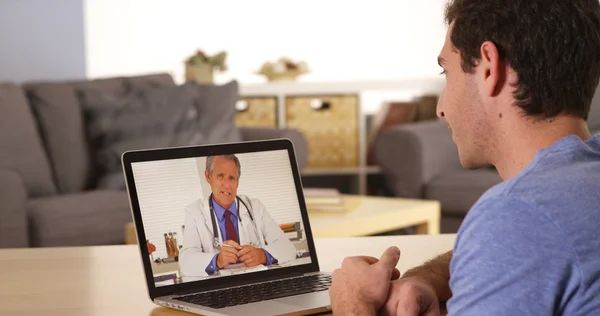 Guy using laptop to talk to doctor — Stock Photo, Image