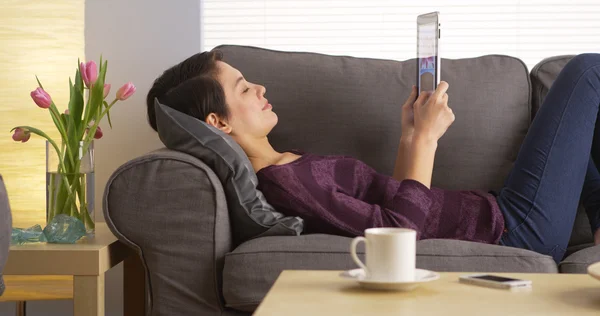 Attraente asiatico donna utilizzando tablet su divano — Foto Stock