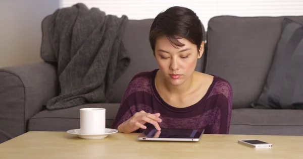 Mujer asiática sentada en la mesa de café con tableta —  Fotos de Stock