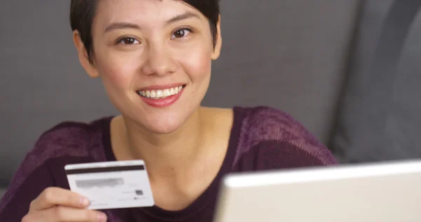 Joyeux mignon asiatique femme tenant carte de crédit — Photo