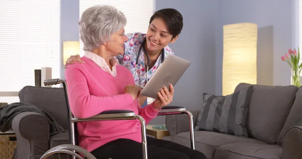 Femme asiatique et patient âgé parlant avec une tablette — Photo