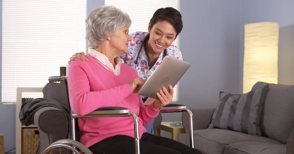 Femme chinoise et patient âgé parlant avec une tablette — Photo