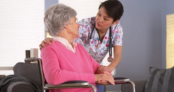 Aziatische verpleegster praten met Senior patiënt — Stockfoto