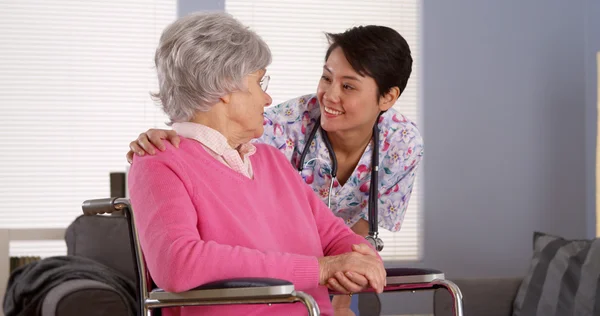 Kinesiska sjuksköterska talar med äldre patient — Stockfoto