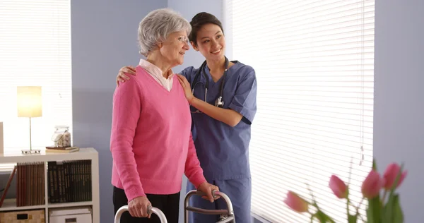 Chinese nurse and elderly woman patient looking out window — Stock Photo, Image