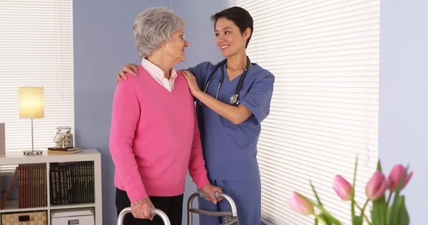 Chinese nurse talking with elderly patient by window — Stock Photo, Image