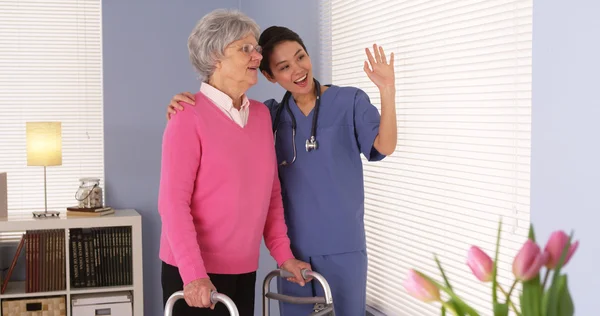 Happy elderly woman patient talking with Asian nurse — Stock Photo, Image