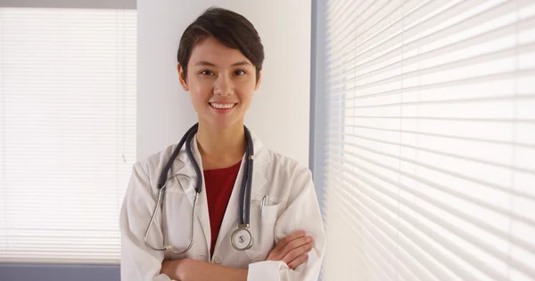 Confiante mulher asiática médico em pé pela janela — Fotografia de Stock