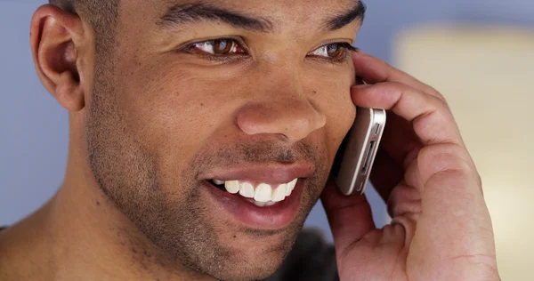 Hombre africano sonriendo escuchando en el teléfono inteligente — Foto de Stock