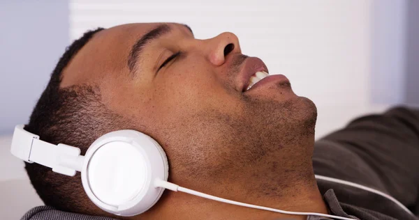 Hombre negro escuchando música con auriculares —  Fotos de Stock