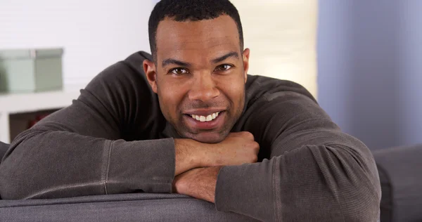 Sorrindo homem negro descansando no sofá — Fotografia de Stock