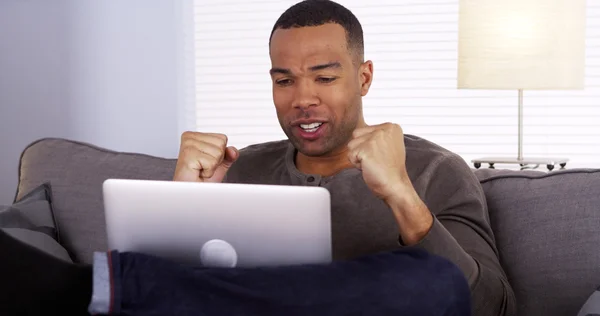 Homem negro assistindo o jogo em seu laptop — Fotografia de Stock