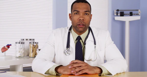 Black doctor listening and talking to camera — Stock Photo, Image