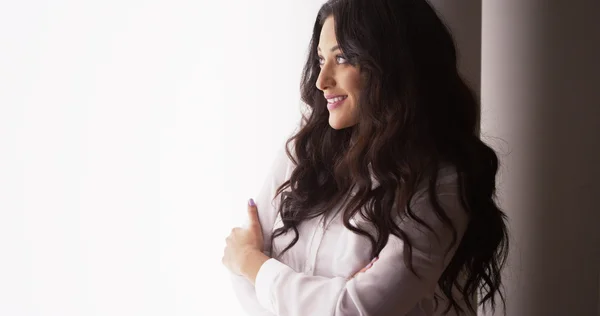 Attractive Hispanic businesswoman standing by window — Stock Photo, Image