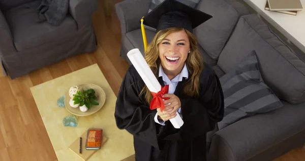 Feliz joven graduada sosteniendo diploma — Foto de Stock