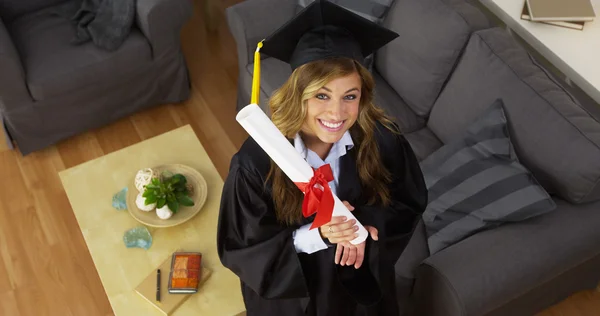 Graduada universitaria que sostiene diploma y sonríe — Foto de Stock