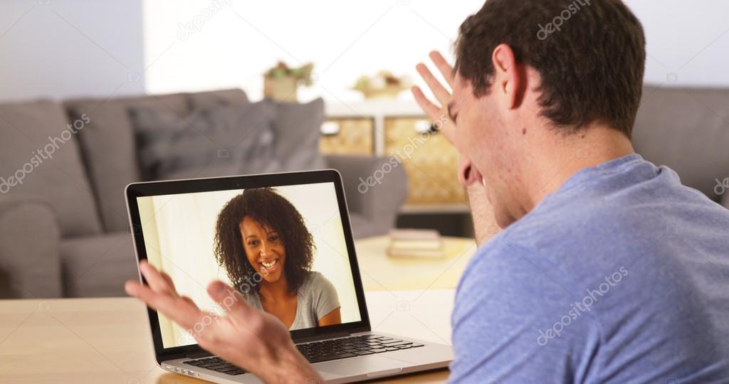 Man webcamming with friend on laptop