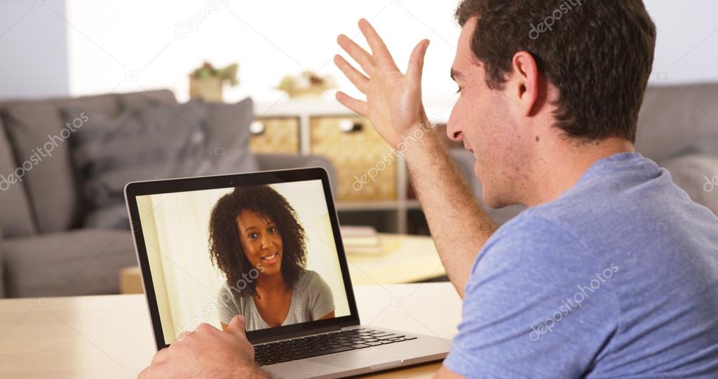 Multi-ethnic friends webcamming on laptop