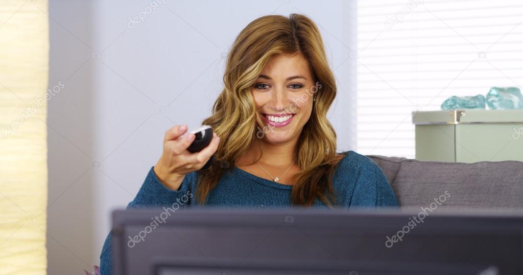 Young woman watching TV on couch