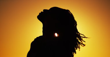 Silhouette of African woman standing at sunset clipart