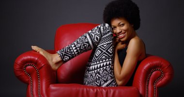 African woman sitting in red armchair clipart