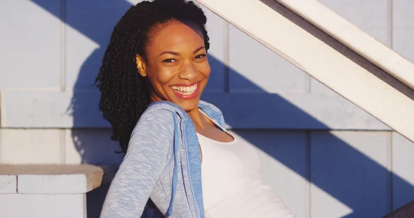 屋外階段が笑っている上に座って幸せ黒人女性 — ストック写真