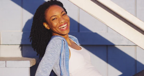 야외 계단 웃음에 앉아 행복 한 흑인 여자 — 스톡 사진