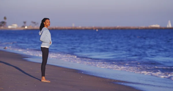 Femme noire profitant de la vue sur l'océan jusqu'à ce que les vagues viennent — Photo