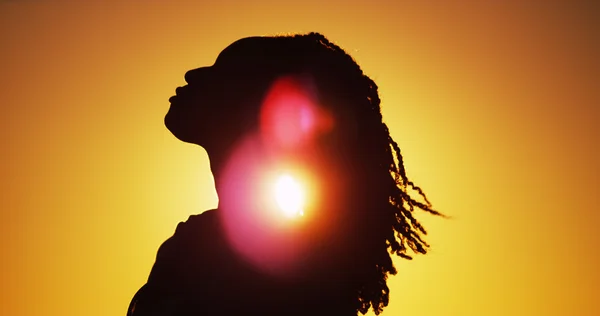Силует африканських жінку, що стоїть на заході сонця — стокове фото