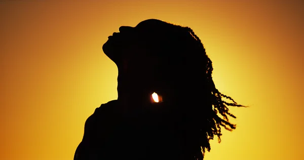 Sziluettjét afrikai nő állandó naplementekor — Stock Fotó