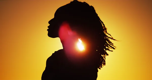 Prachtige silhouet van Afrikaanse vrouw permanent bij zonsondergang — Stockfoto