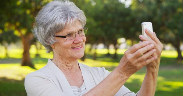 Hippe Oma macht Selfies im Park — Stockfoto