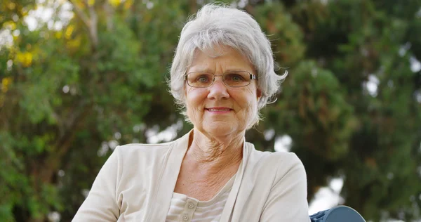 Bonne grand-mère assise sur le banc — Photo