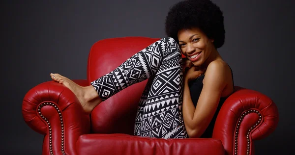 赤い肘掛け椅子に座っているアフリカの女性 — ストック写真