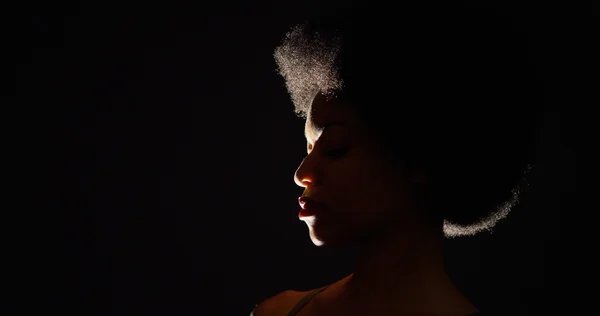 Backlit studio shot van zwarte vrouw drinkwater uit de fles — Stockfoto
