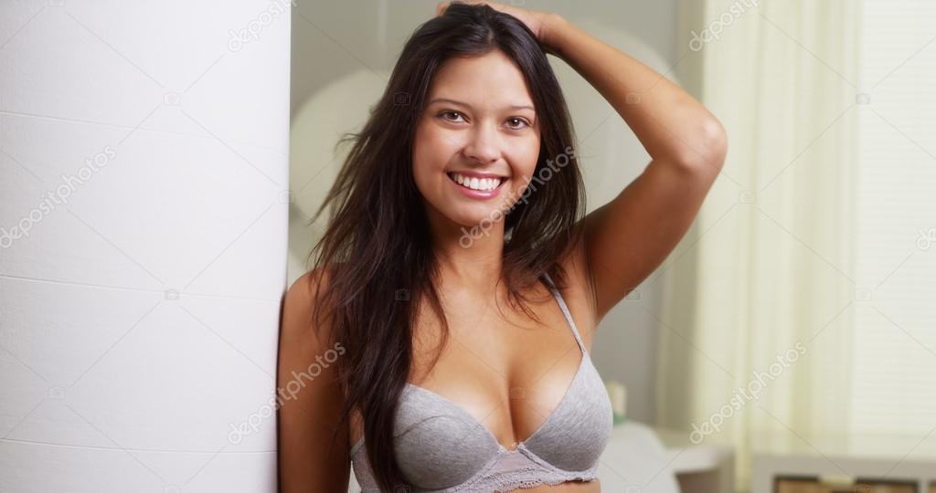Hispanic woman in lingerie smiling at camera