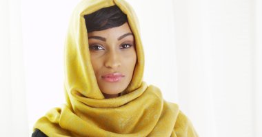 Cam kenarında altın başörtüsü giyen Afrika kadın