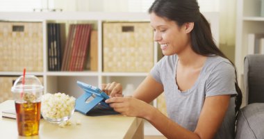 İspanyol kadın gülüyor ve tablet sehpa üzerinde kullanma