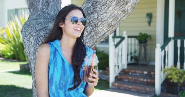 Ağaç içerek duran karışık ırk kadın buzlu çay