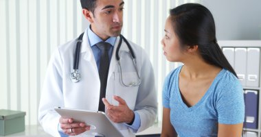 Hispanic doctor talking with patient with test results on tablet clipart