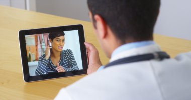 İspanyol doktor tablete genç kadın hasta ile konuşmak