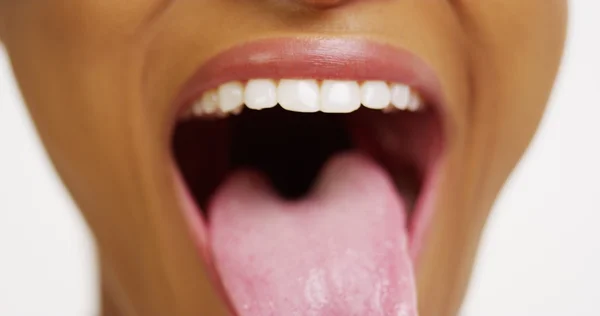 Close up de mulher africana com dentes brancos sorrindo e furando a língua para fora — Fotografia de Stock