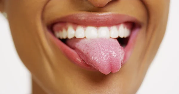 Primer plano de la mujer africana con los dientes blancos sonriendo y sacando la lengua — Foto de Stock