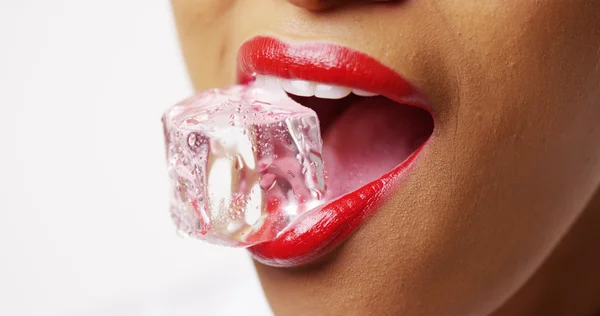 Close up de mulher segurando gelo na boca no fundo branco — Fotografia de Stock